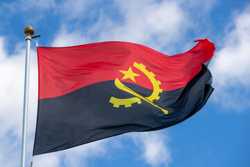 The flag of Angola in the beautiful sky flutters the fabric of the national flag of Angola. Great for news