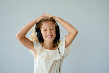 Naklejka premium People, music, emotions concept. Delighted carefree female dances in rhythm of melody, closes eyes listens loud song in headphones