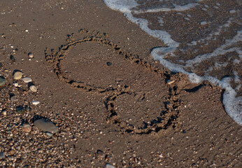 Fototapeta na wymiar Heart Symbol On a Sand Of Beach With Soft Wave On Background