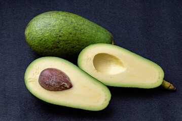 Cut avocado fruit, Variety: Fuerte, Black felt background