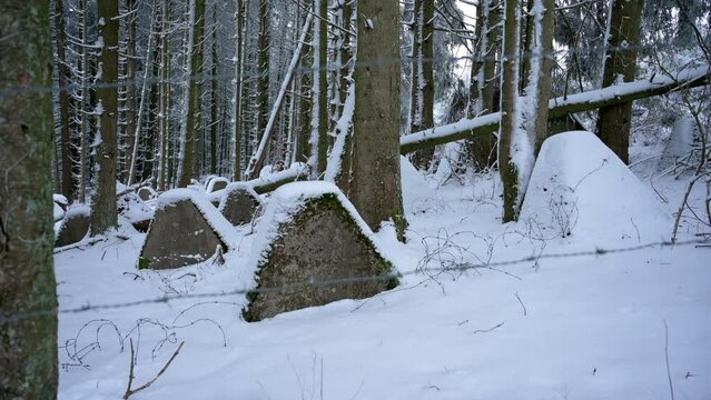 Anti tank wall or dragon's teeth on the Westwall covered in snow in a forest 