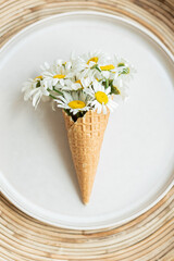 Composition of ice cream cone with chamomile flowers. Flat Lay. Top View. Creative summer concept