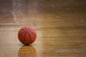 orange color basketball on old maple hardwood floor 
