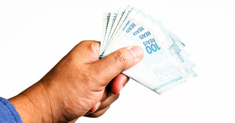 Banknotes of one hundred reais from brazil, social benefit payment day. 100 reais being delivered by male hand, emergency aid from the government.