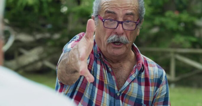 Portrait of Senior Card Player Getting Lucky with the Winning Card, Being Victorious in a Friendly Game with his Friends. Elderly People Enjoying the Summer Weather Outdoors in a Park