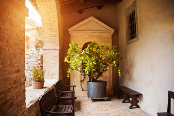 Inner yard or porch of an old church with benches and lemon tree