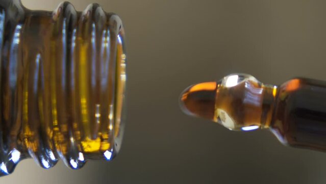 super macro vertical video Droplets of cbd oil filling Dropper Bottle