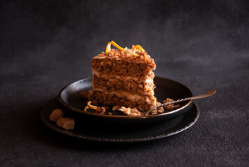 Piece of homemade cake with cinnamon on black plate