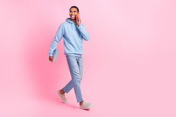 Full length photo of successful businessman wear stylish clothes go modern device shop look empty space isolated on pink color background