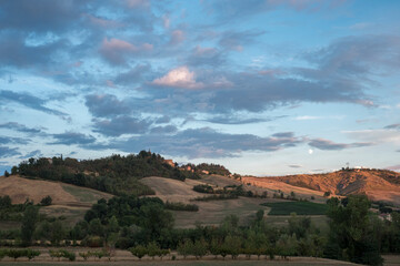 Fototapeta na wymiar Clouds at sunset over italian rolling hills