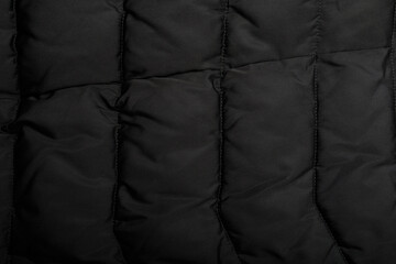 stitched down jacket or quilted outer garments black fabric texture background