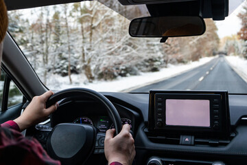 man driving a car on an winter road. Close-up of hands on a steering wheel. view from the driver's back. back view