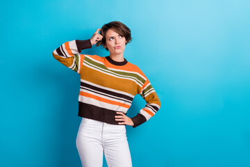 Photo of doubtful unsure woman dressed striped pullover arm head looking empty space isolated blue...