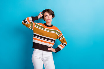 Photo of doubtful unsure woman dressed striped pullover arm head looking empty space isolated blue color background