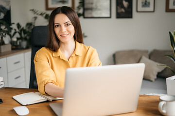 Young happy smiling professional business woman, female company worker or corporate manager posing in modern office working, looking at camera, portrait.
