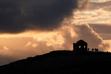 Silhouette of people and a ruin at sunset