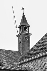 Black and white picture of the clock tower of the old church.