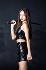 Beautiful dangerous woman with samurai katana sword. Vertical photography.