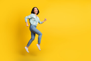 Fototapeta na wymiar Full length photo of cute optimistic cheerful girl dressed blue cardigan jeans running on sale isolated on yellow color background