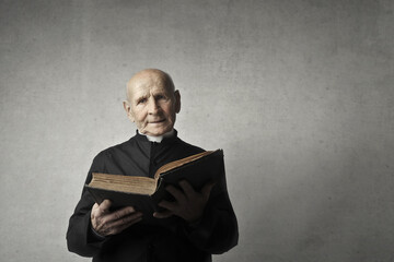 portrait of an elderly priest with a bible in hand