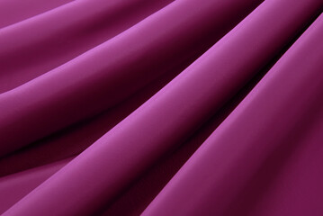 Texture of a smooth luxurious, elegant fabric in burgundy, purple, red. Purple satin or silk fabric...
