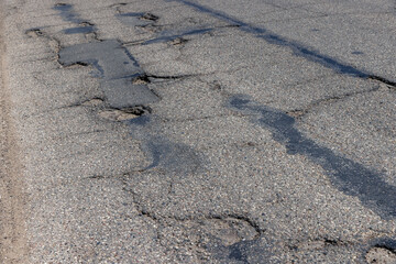 An old paved road with a lot of holes and damage