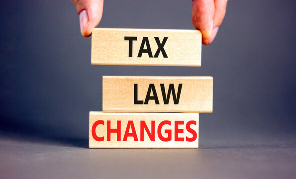 Tax law changes symbol. Concept words Tax law changes on wooden blocks on a beautiful grey table grey background. Businessman hand. Business tax law changes concept. Copy space.