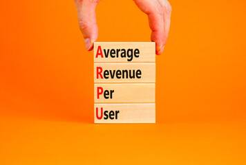 ARPU average revenue per user symbol. Concept words ARPU average revenue per user on wooden block on beautiful orange background. Business ARPU average revenue per user concept. Copy space.