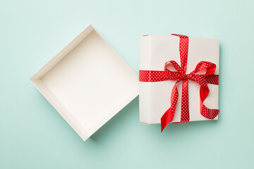 Open gift box on color background, top view