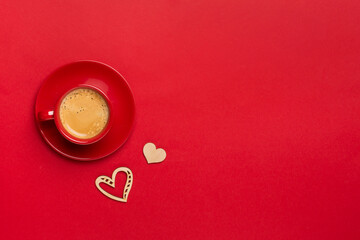 Red cup of coffee with hearts on color background, top view