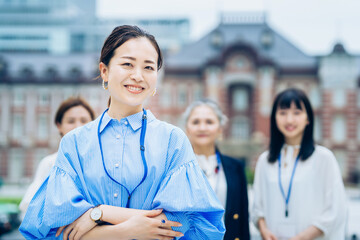 屋外に並ぶビジネスウーマンたち