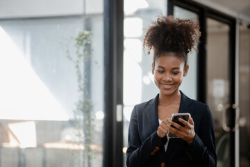 Close up american woman holding smartphone, she is using smartphone browsing social media and chatting with friends on online messaging app. The concept of using a smartphone.
