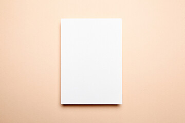 Greeting card mockup beige background, top view, flat lay. Blank holiday card or flyer