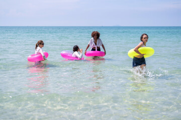 Teenage girl friendship enjoy laughing play on sea swimming with water inflation toy on blue sky day