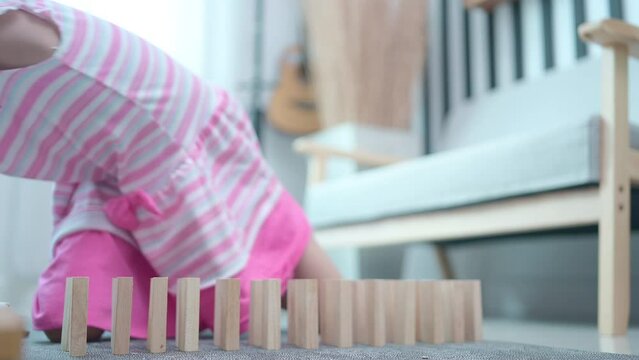 A Little girl having fun playing dominoes in the living room of the house