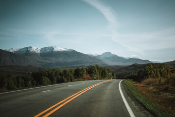 Empty road with a view on majestic mountains and the norwegian landscape in autumn