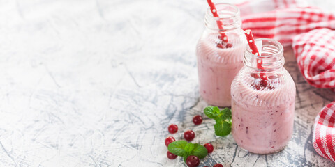 Homemade milkshake or smoothie with a cranberry in bottles on a table. Copy space. Fancy non alcoholic drinks