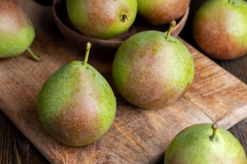 Whole ripe green pears on the board