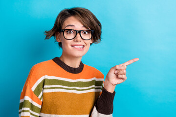 Photo of doubtful unsure woman dressed striped pullover eyewear biting lip pointing empty space...