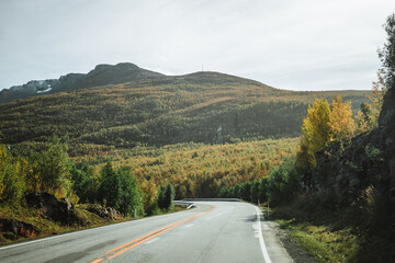 Empty road with a view on majestic mountains and the norwegian landscape in autumn