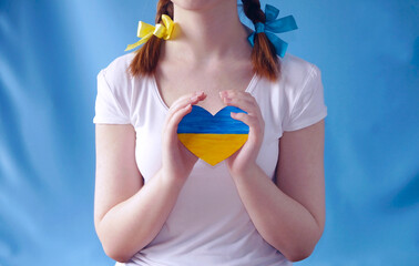 The girl holds the heart of Ukraine in her hands. Children for Peace.