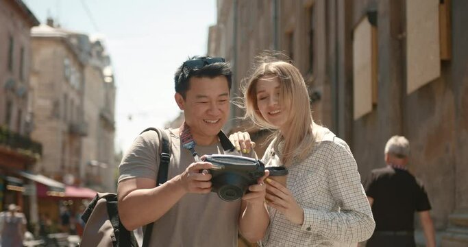 Happy tourists looking at photos on camera