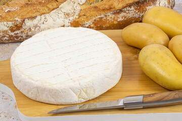 fromage Reblochon et pommes de terre sur une planche à découper