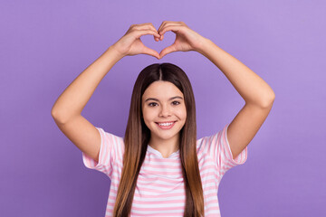 Photo of adorable shiny lady wear striped white t-shirt rising arms showing heart isolated violet color background