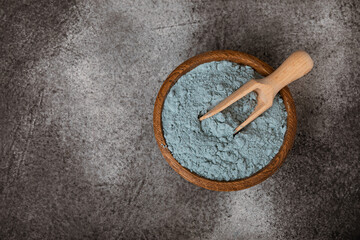 Blue spirulina powder in bowls and spoon on black marble background. Natural vegan superfood. food supplement. place for text. Copy space.