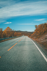 Empty road with a view on majestic mountains and the norwegian landscape in autumn