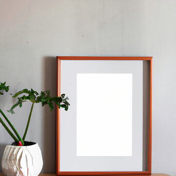 A mock up of an empty picture frame on a grey wall in a snow white living room with a modern design, depicting an art display as part of a home staging and minimalism concept.