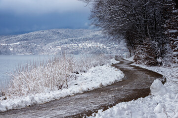 Krajobraz wodny nad jeziorem. Zimowa, śnieżna i mroźna sceneria. Styczniowa przyroda.	