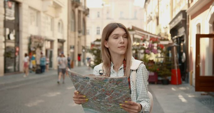 Young woman using a map in a European city