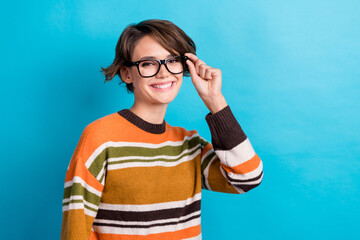 Photo of cheerful positive lady wear striped sweater arm spectacles smiling empty space isolated blue color background